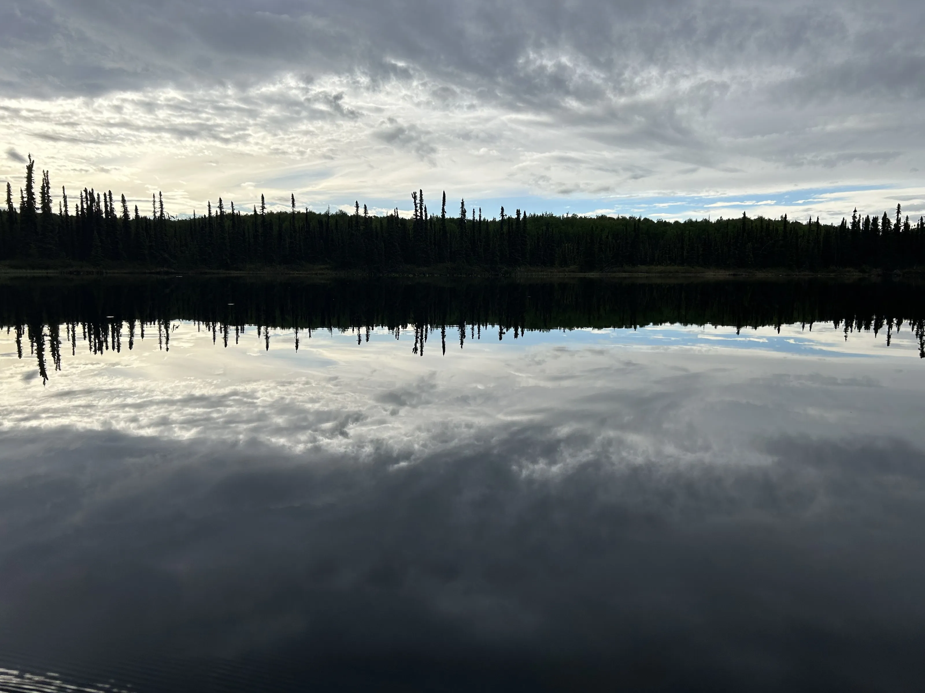 Early morning kayaking on a lake as smooth as a mirror
