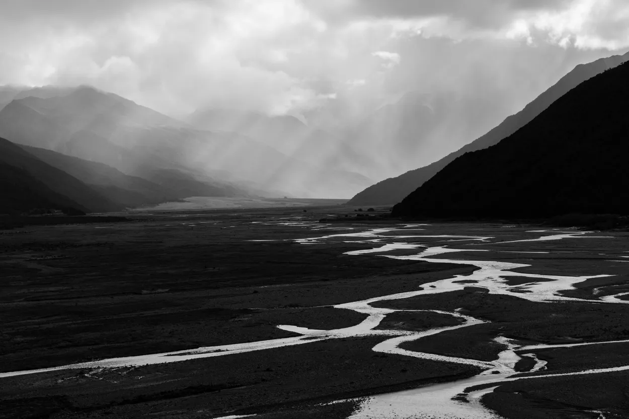 Sun shining through storm clouds on the Waimakariri River, South Island, New Zealand