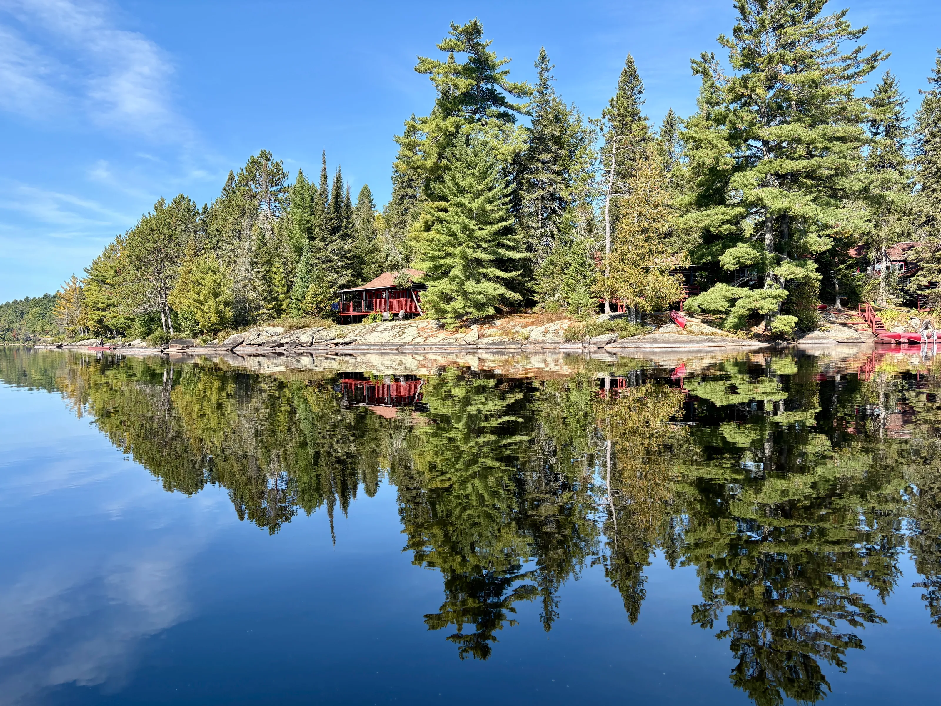 Log Cabins and trees reflected in the Lake of Two Rivers