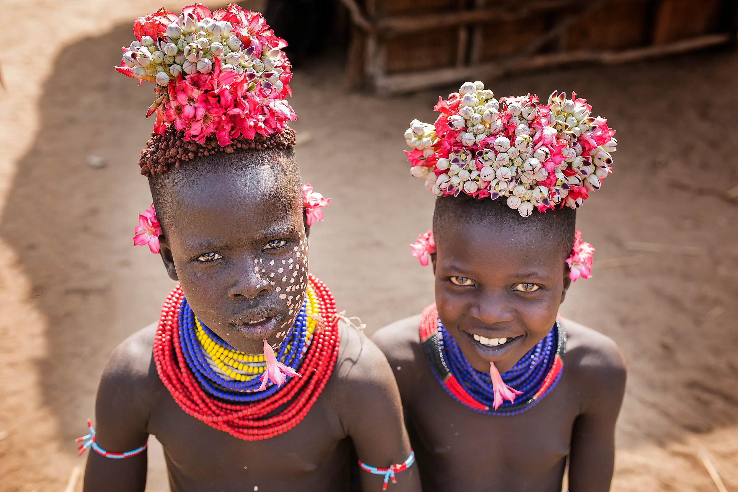 Two Young Karo Tribe Children with Flower-Adorned Hair in Ethiopia