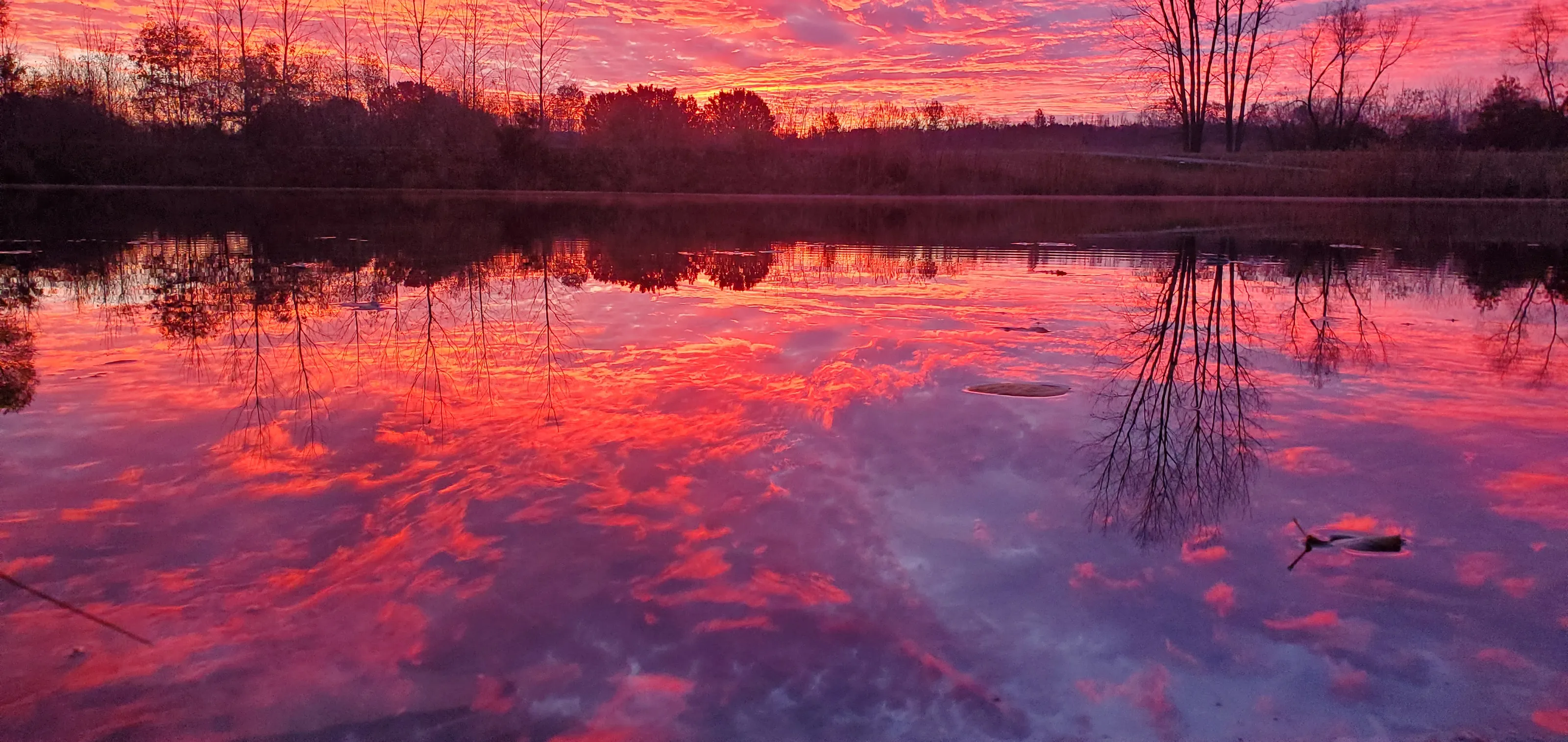 Early morning fire dancing across the still mirror