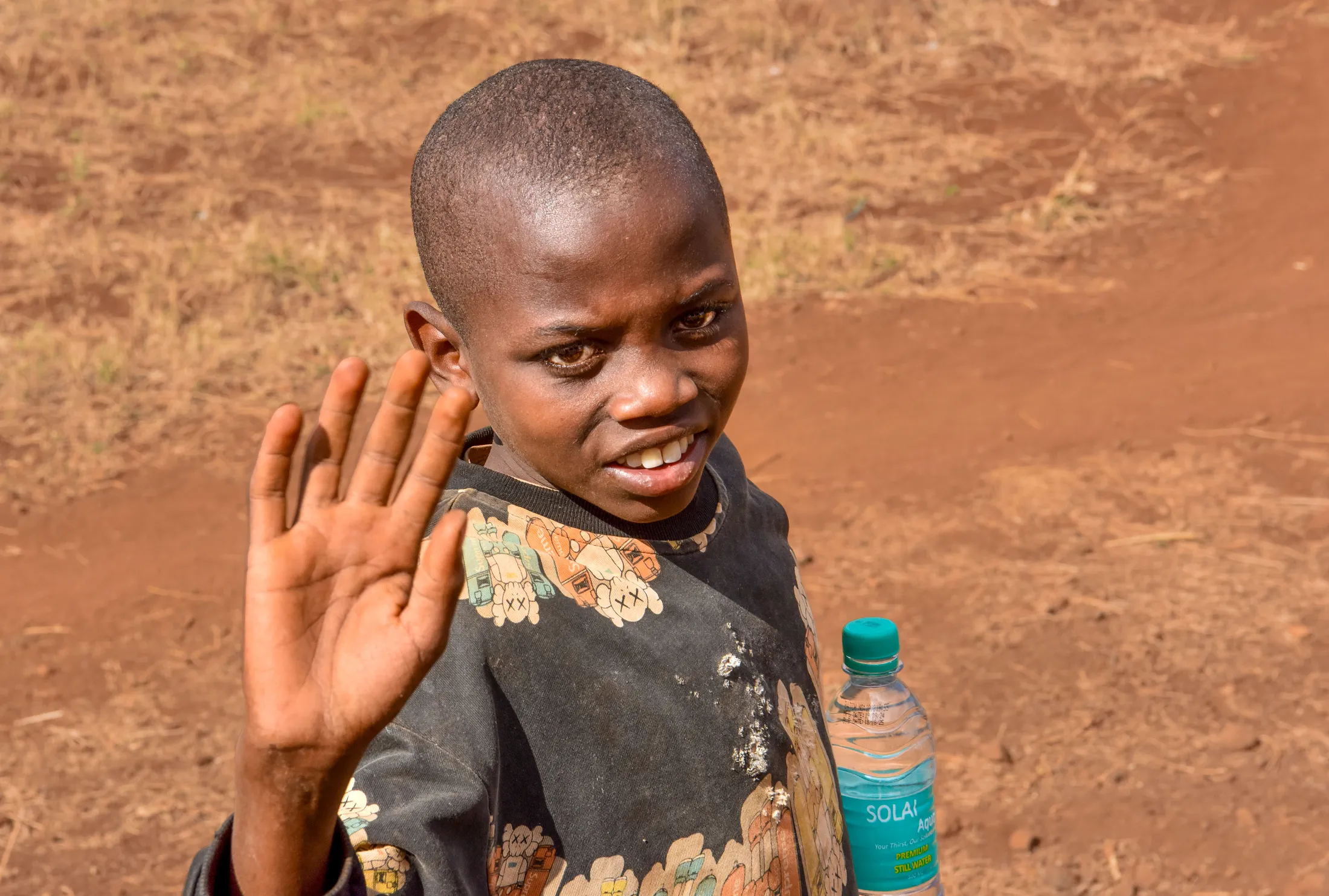 Kenian boy waving