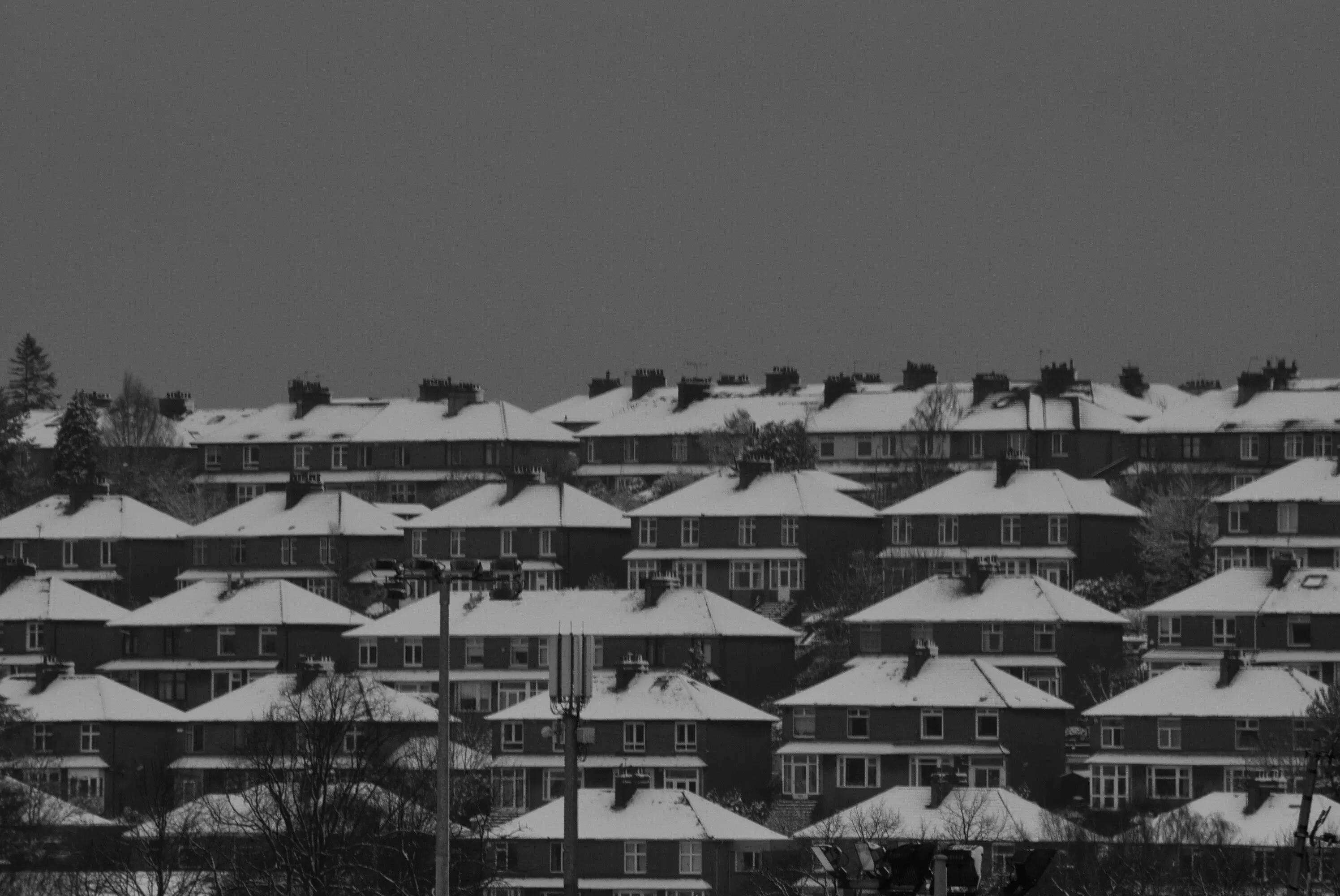 Roof top with snow and broody snowladen sky behinds