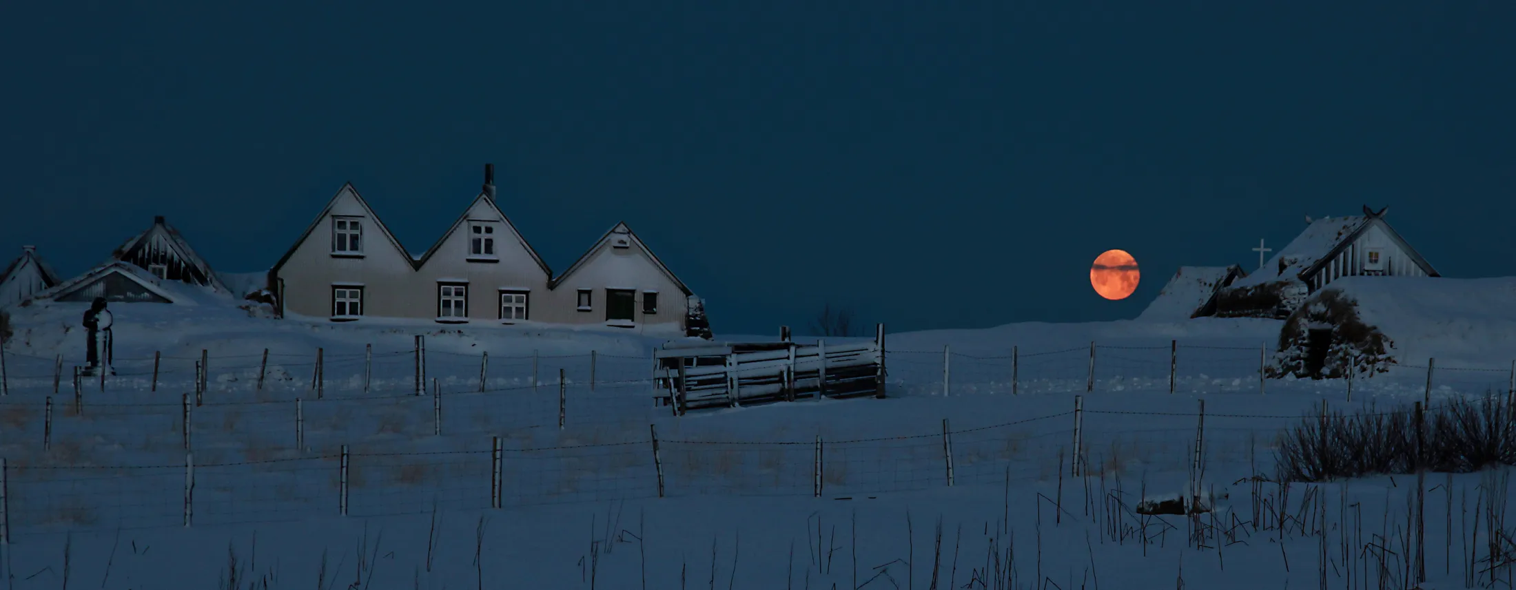 Setting of full moon over old farm houses, Iceland
