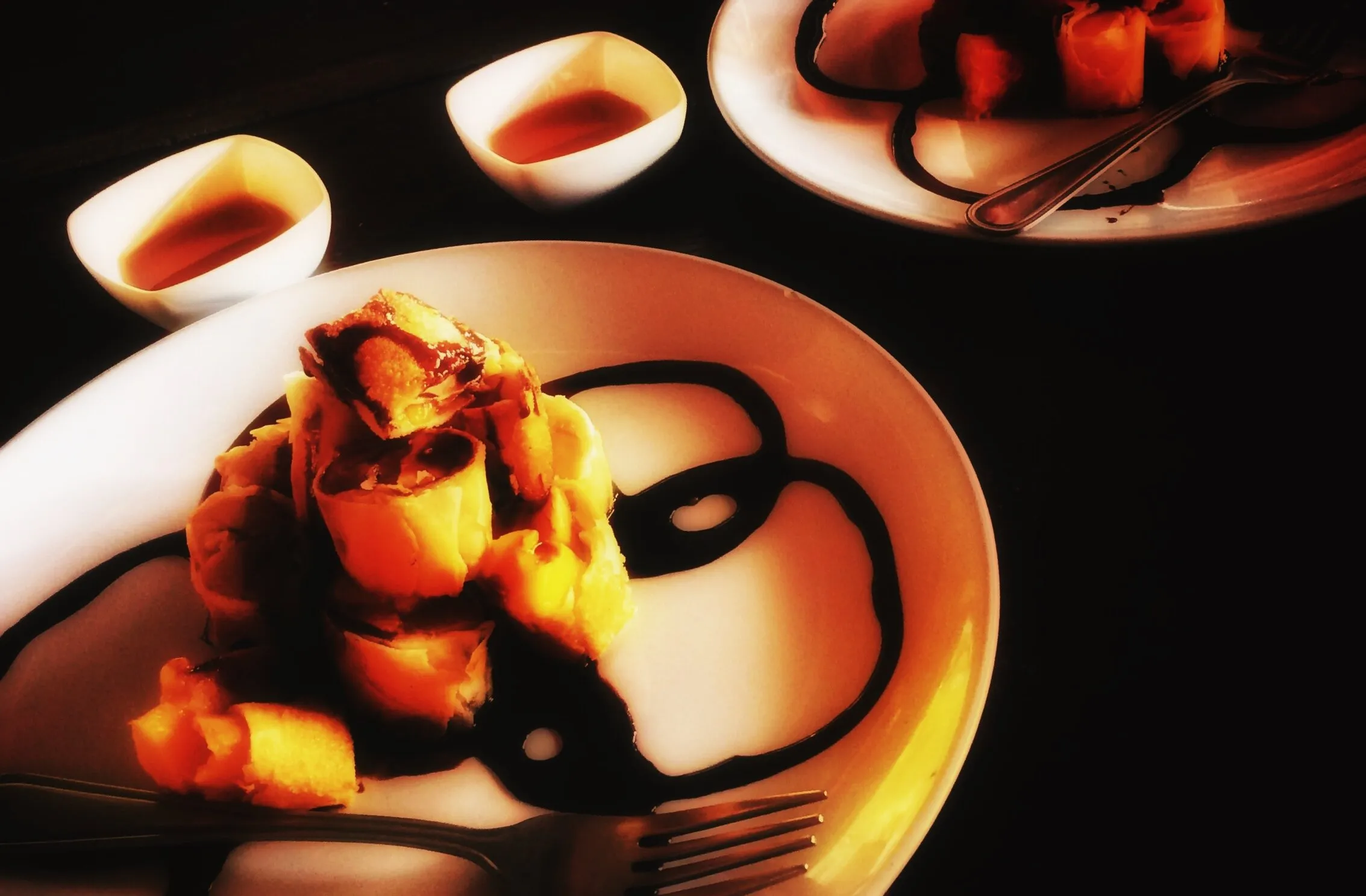 Deep fried mango and banana spring rolls served with honey and melted chocolate