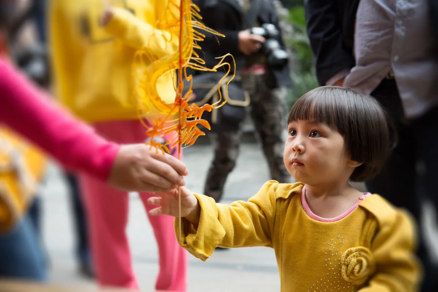 Chinese child excitedly receives candy dragon stick