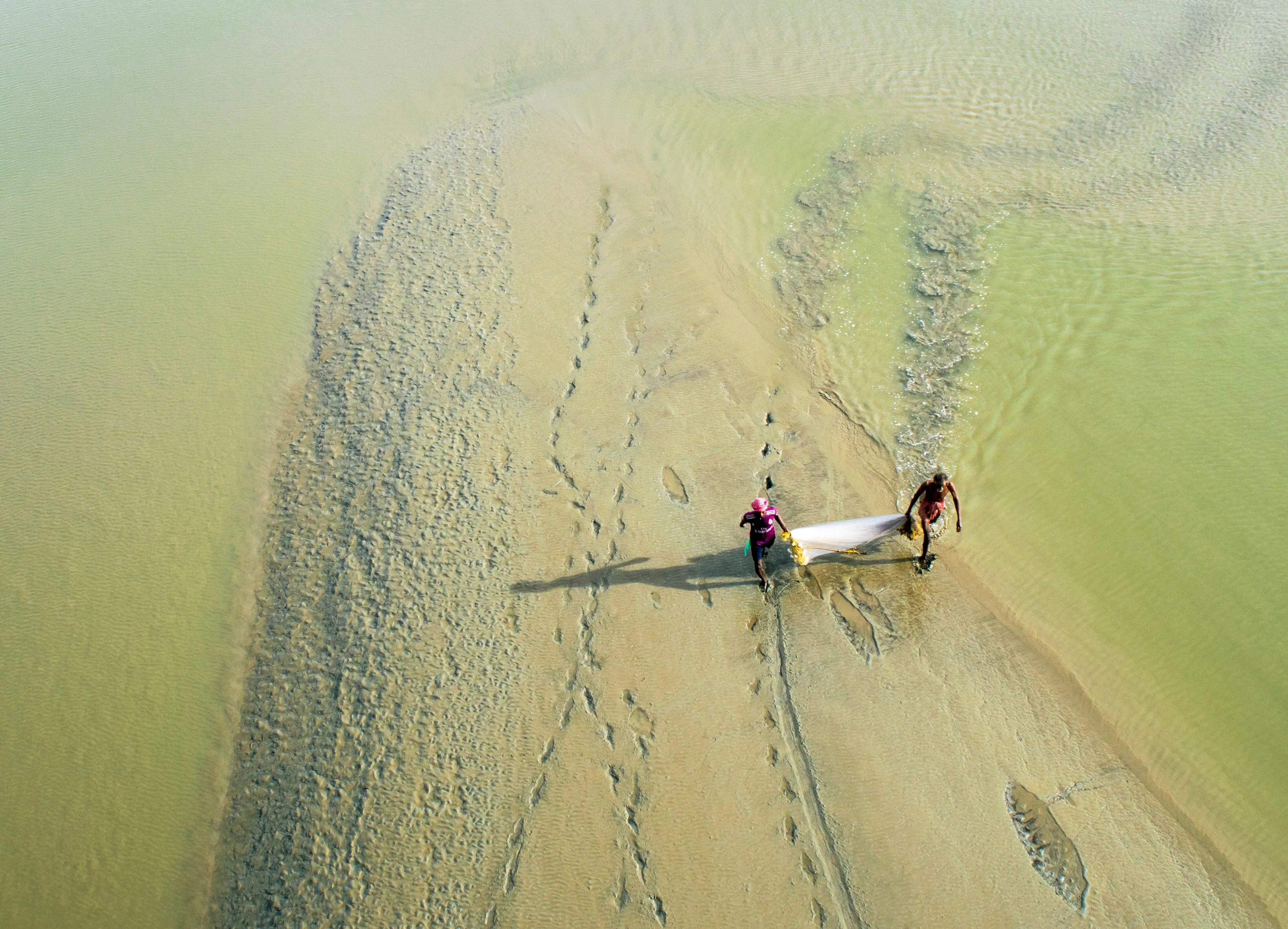 Two fishermans work with black struggling shadow