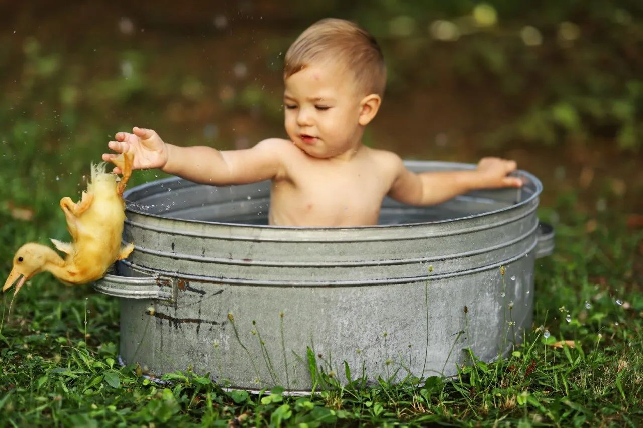 Kid and duck playing in the bath