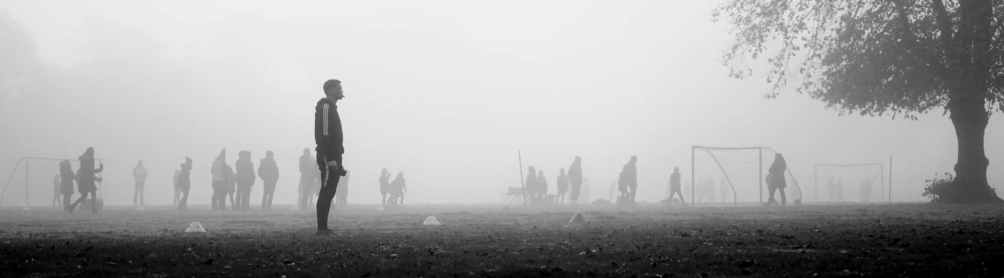 Coach preparing for a football match in a local park for a grassroots U8's game on a foggy morning