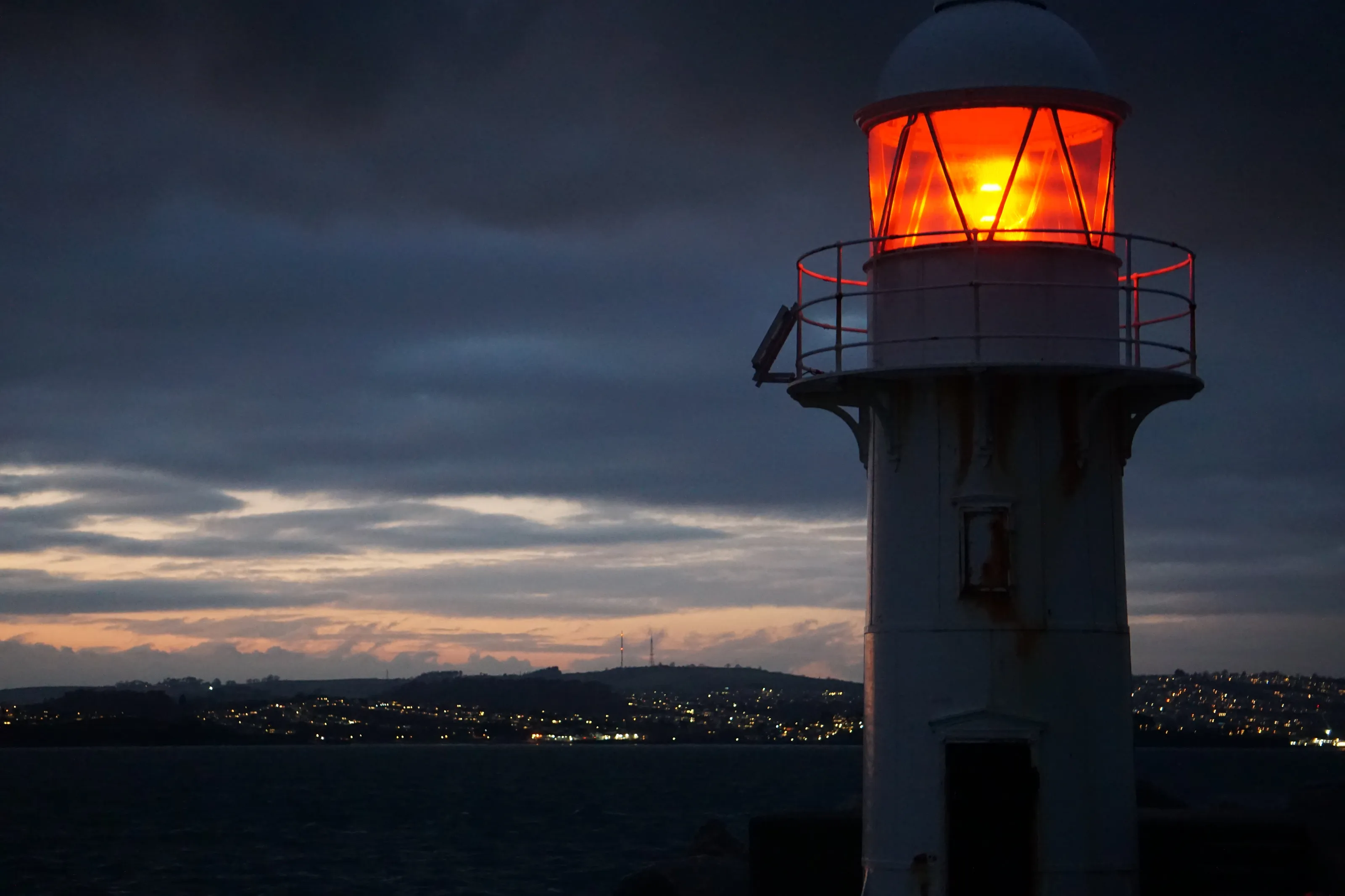 breakwater lighthouse lit at dusk