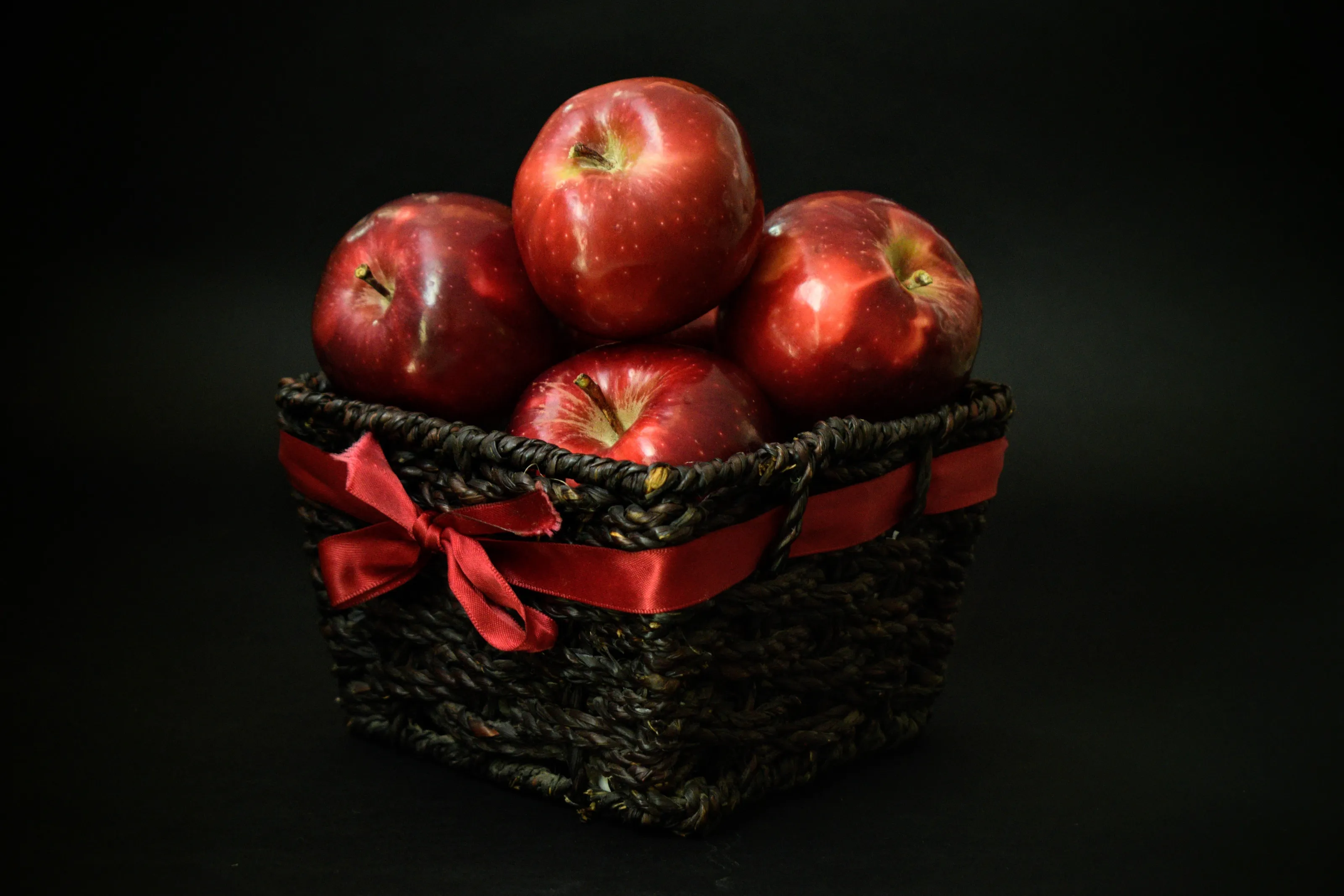 Red Apples In Textured Basket With Black Background