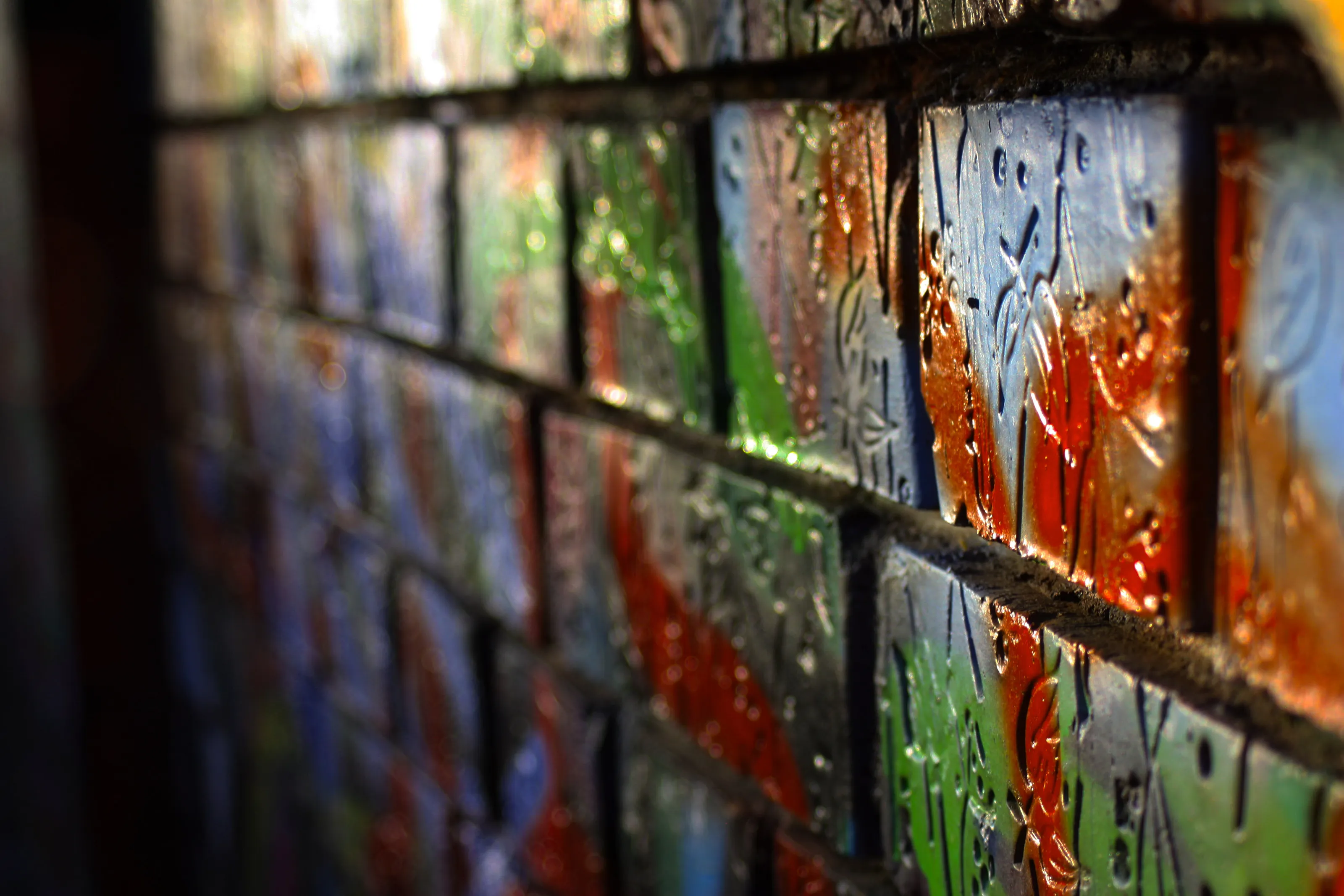 Really old brick wall with vibrant graffity up close