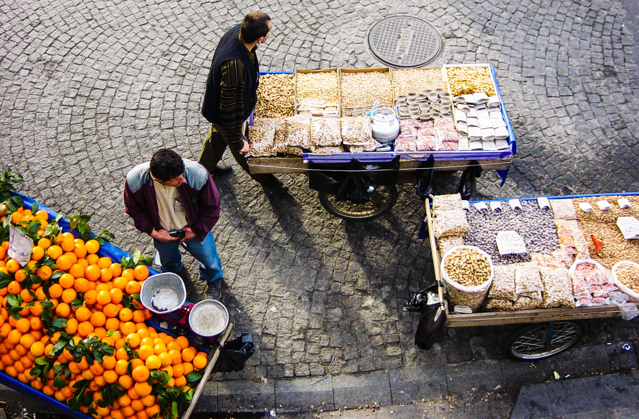 fruit vendors selling oranges and nuts from a typical turkish market cart
