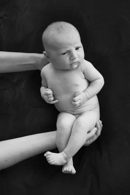 Thoughtful or grumpy, I am not quite sure....Baby with mothers arms.