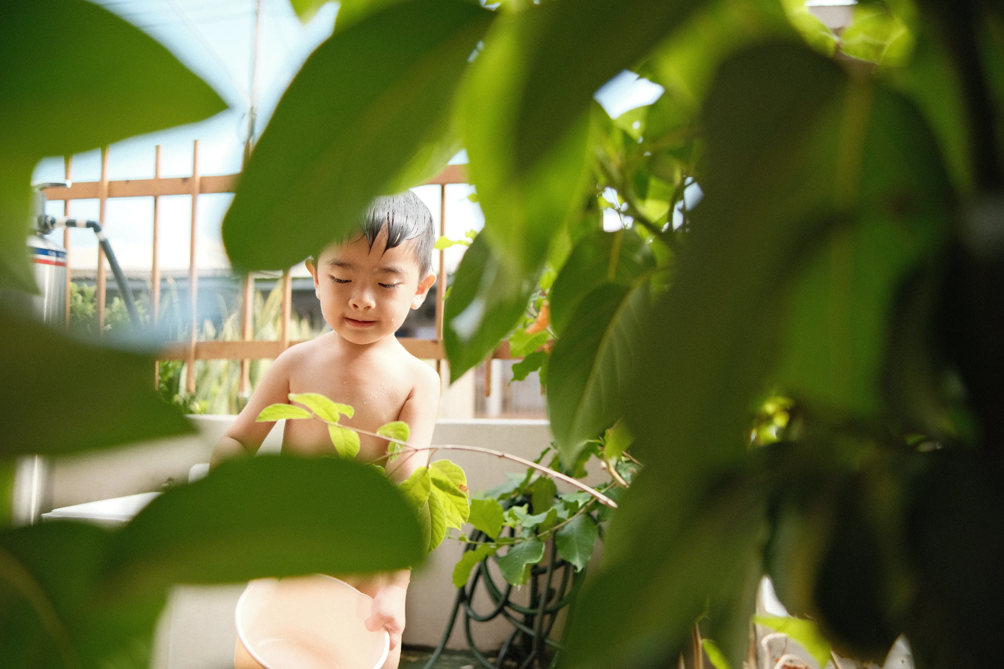 Kid taking bath outside the house