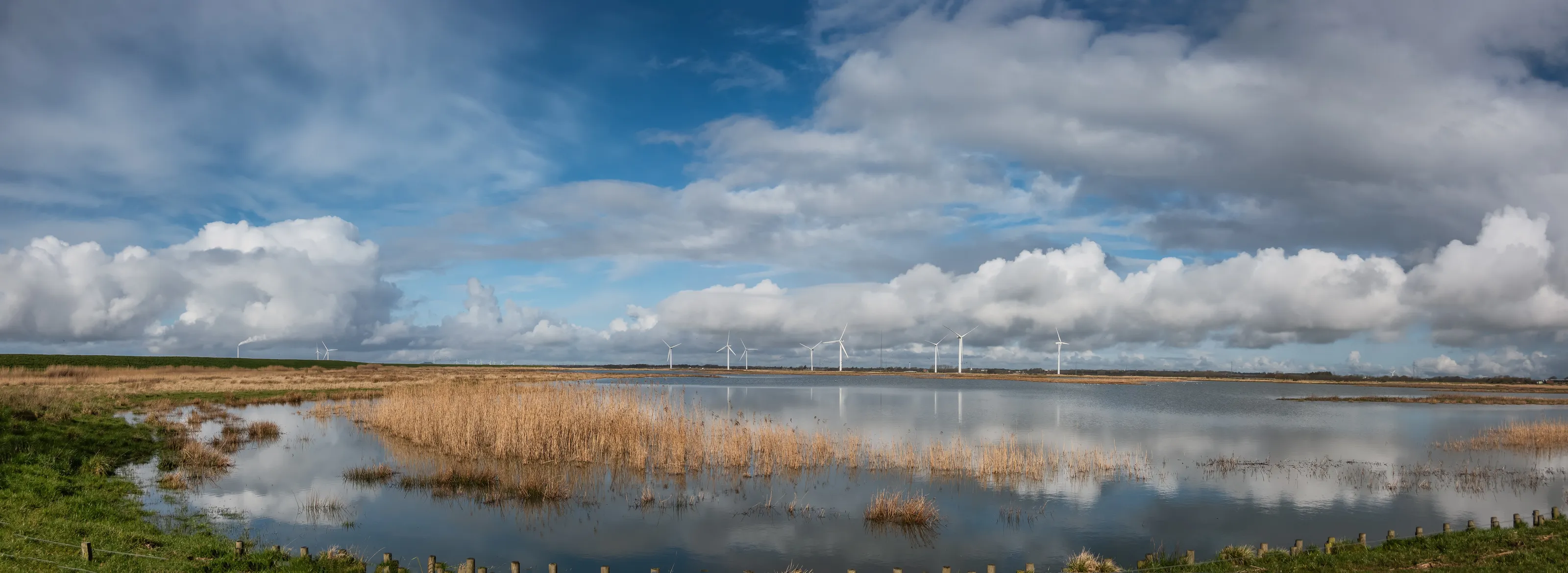 Wind turbines Sneum Sluse behind the dikes with bird areas, Esbjerg Denmark