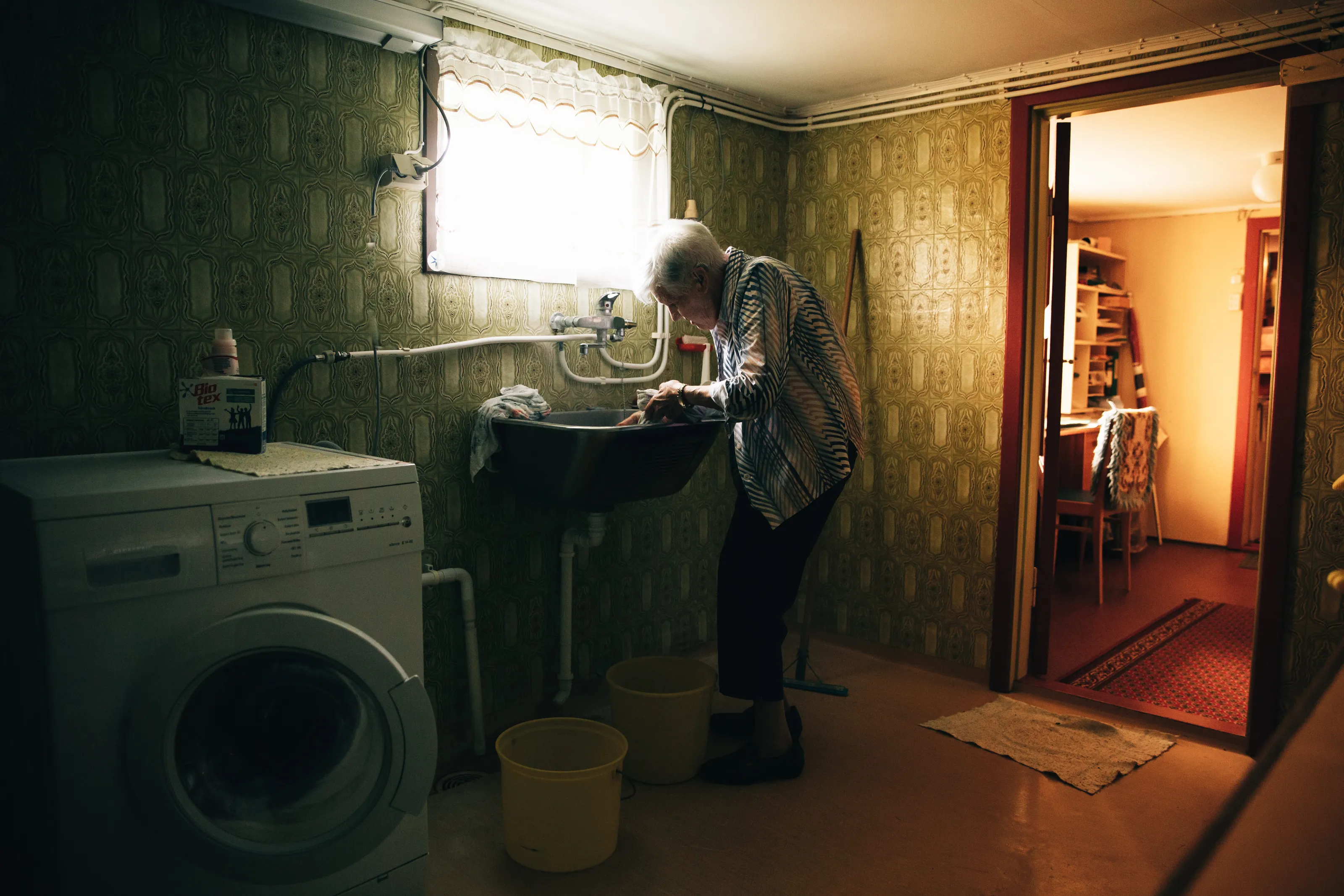 Old poor woman washing clothes by hand