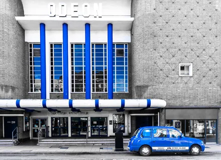 Art Deco cinema and blue Taxi cab.