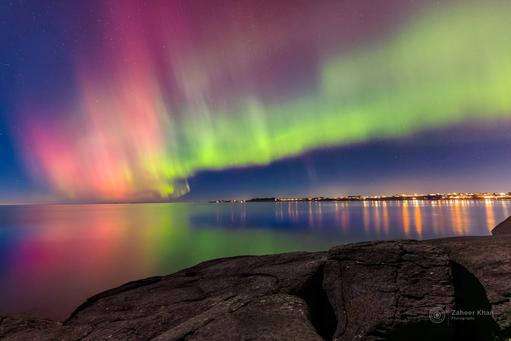Aurora borealis with reflection on the sea.