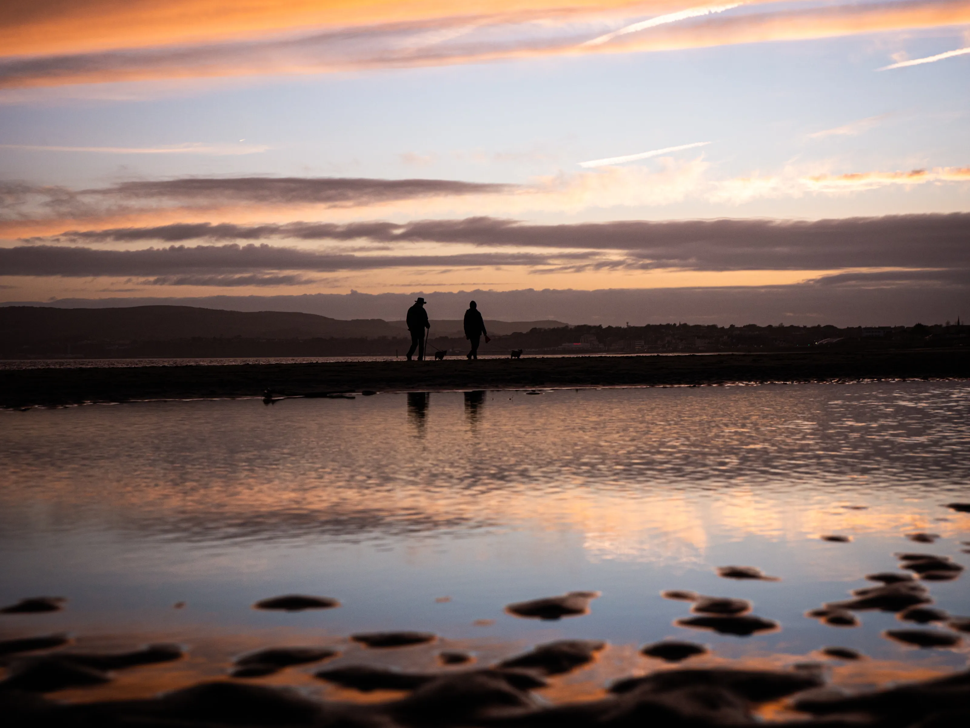 Dog walkers at sunset
